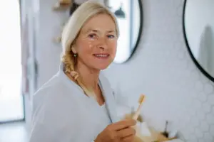 Lady In Her Bathroom Brushing Teeth